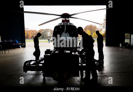 Rastede, Deutschland. 14 Nov, 2018. Hubschrauberpiloten der Polizei Niedersachsen stehen in einer Halle in einem Helikopter und die Maschine für den Transport vorbereiten. Credit: mohssen Assanimoghaddam/dpa/Alamy leben Nachrichten Stockfoto