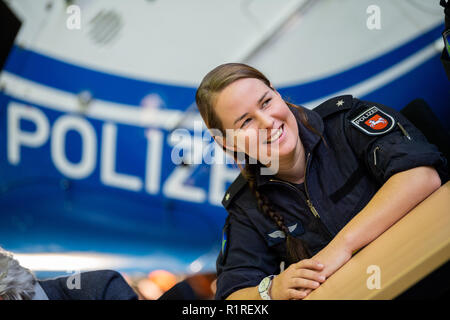 Rastede, Deutschland. 14 Nov, 2018. Kirsten Böning, erste weibliche Hubschrauberpilot der Polizei Niedersachsen, sitzt vor einem Polizei Hubschrauber während einer Pressekonferenz. Credit: mohssen Assanimoghaddam/dpa/Alamy leben Nachrichten Stockfoto