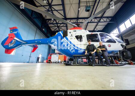 Rastede, Deutschland. 14 Nov, 2018. Kirsten Böning und Immo Graß - beide Hubschrauber Piloten der Polizei Niedersachsen, sitzen auf dem Fahrwerk eines Polizeihubschraubers. Credit: mohssen Assanimoghaddam/dpa/Alamy leben Nachrichten Stockfoto