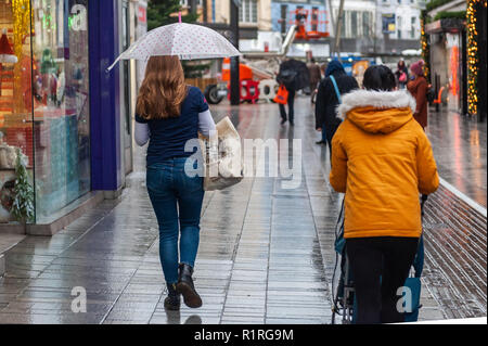 Cork, Irland. 14 Nov, 2018. Ein shopper trotzt der Elemente in die Stadt Cork während einer Periode sehr nassem Wetter. Es werden keine oben lassen, mit mehr vom Gleichen Prognose für morgen. Credit: Andy Gibson/Alamy Leben Nachrichten. Stockfoto