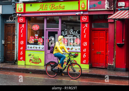 Cork, Irland. 14 Nov, 2018. Eine Frau Zyklen entlang der Washington Street in die Stadt Cork während einer Periode sehr nassem Wetter. Es werden keine oben lassen, mit mehr vom Gleichen Prognose für morgen. Credit: Andy Gibson/Alamy Leben Nachrichten. Stockfoto