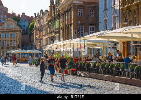 Poznan Marktplatz, Blick von Menschen zu Fuß hinter einem Street Cafe auf dem Marktplatz (Stary Rynek) in Posen, Polen. Stockfoto