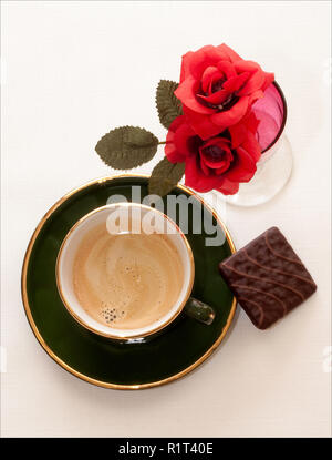 Es gibt Kaffee. Und dann gibt es tollen Kaffee. Und gibt es tollen Kaffee mit einem prunkvoll, dunkel schokoladig Keks. Und Rosen! Stockfoto