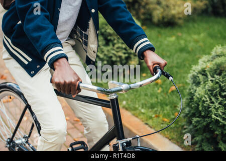 7/8-Ansicht der afrikanischen amerikanischen Mann reiten Fahrrad im Park Stockfoto