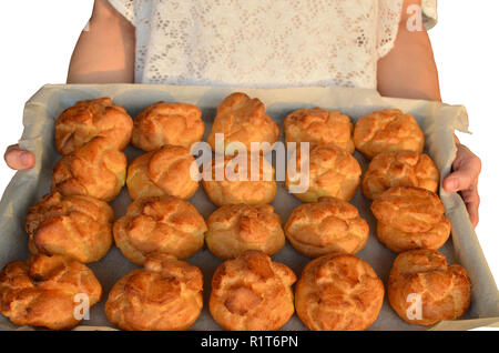 Frau mit Donuts auf ein Backblech, gerade heraus aus dem Ofen genommen Stockfoto