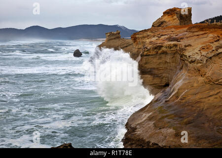 Oder 02379-00 ... OREGON - Wellen gegen bunten Sandsteinfelsen am stürmischen Tag am Kap Kiwanda State Park. Stockfoto