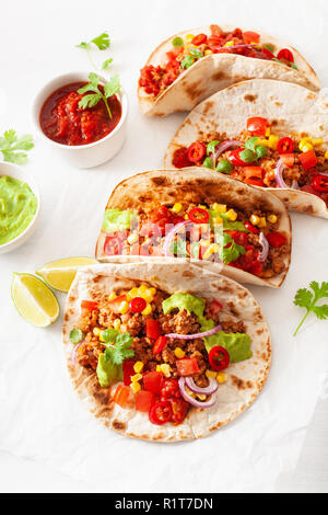 Mexikanische Rind- und Schweinefleisch Tacos mit Salsa, Guacamole und Gemüse Stockfoto