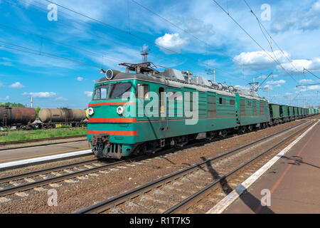 Elektrische Lokomotive mit Güterzug auf der Station im Sommer Stockfoto