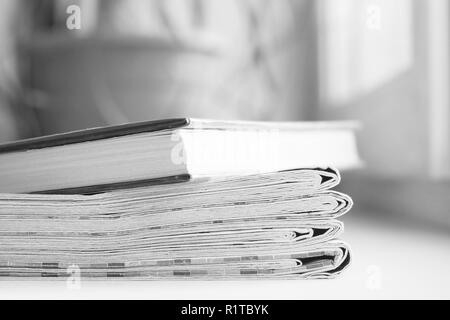 Gefaltete Zeitung und Buch. Täglich frisch Papiere mit Nachrichten- und Literatur. Konzept für das Lesen und Studieren Stockfoto