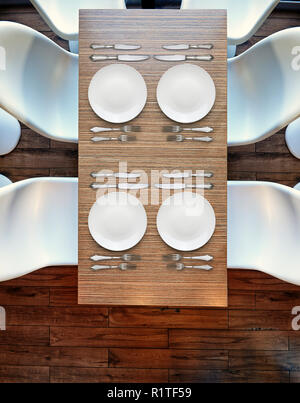 Draufsicht von oben auf vier leere Teller auf Holztisch, Plastikstühle und Parkettboden Stockfoto