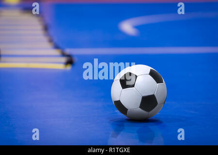 Fußball-Fußball-Kugel auf Futsal Feld. Blau Futsal Training Tonhöhe. Ausbildung Agility Ladder im Hintergrund Stockfoto