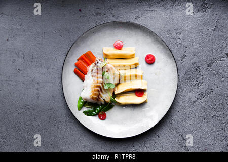 Ästhetische Filet vom Kabeljau mit Knödel, Karotten, grüne Sweet Pea und Tomaten auf vegetarisches Restaurant Stockfoto