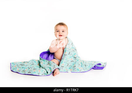 Das Baby unter einem Handtuch. Alter von 10 Monaten. Es ist auf einem weißen Hintergrund isoliert Stockfoto