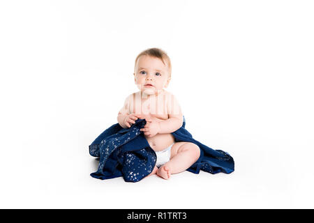 Das Baby unter einem Handtuch. Alter von 10 Monaten. Es ist auf einem weißen Hintergrund isoliert Stockfoto