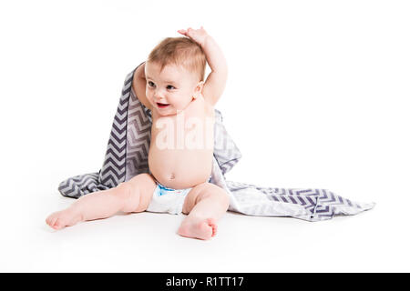 Das Baby unter einem Handtuch. Alter von 10 Monaten. Es ist auf einem weißen Hintergrund isoliert Stockfoto