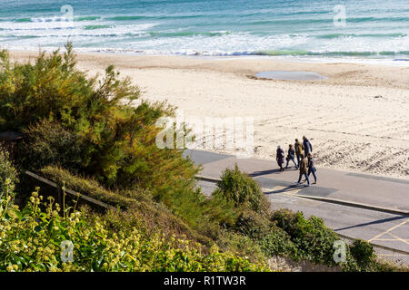 Gruppe von Personen, die für einen Herbst Sonntag Nachmittag einen Spaziergang entlang der Strandpromenade, Strand von Bournemouth, Großbritannien Stockfoto