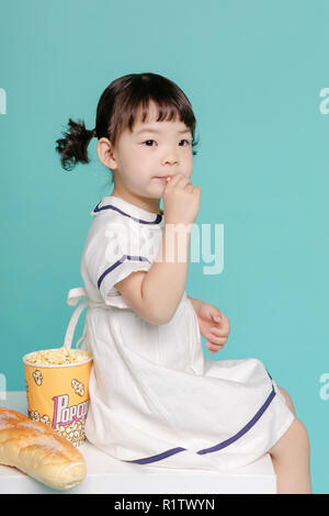 Kleine hübsche asiatische Mädchen lachend Porträt mit Milch und Brot, gesunden und glücklichen Leben. Stockfoto