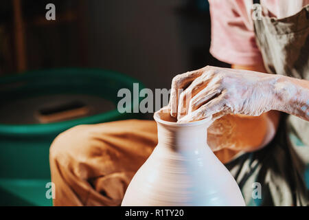 Ansicht von oben der Mann, der Kanne auf Keramik Rad. Potter Formen der Ton Produkt - Kanne - mit professionellen Werkzeugen, Ansicht von oben. Inhaber kleiner Unternehmen worki Stockfoto