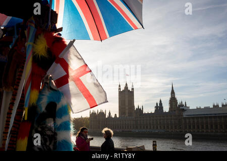 An dem Tag, an dem Premierminister Theresa können Petitionen ihr Kabinett auf die laufenden Verhandlungen der EU zu verlassen, dem Vereinigten Königreich und englische Flaggen hängen zu einem touristischen souvenir Stall gegenüber der Kammern des Parlaments auf der Themse, am 14. November 2018 in London, England. Stockfoto