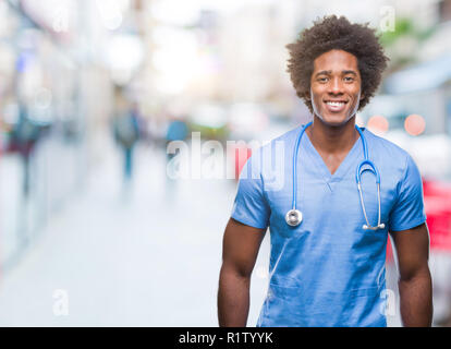 Afro-amerikanische Chirurg Arzt Mann über isolierte Hintergrund mit einem glücklichen und kühlen Lächeln auf dem Gesicht. Glückliche Person. Stockfoto
