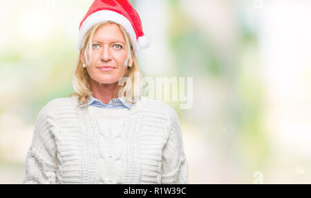 Blonde Frau mittleren Alters tragen Mütze über isolierte Hintergrund mit ernsten Gesichtsausdruck. Einfache und natürliche in die Kamera schaut. Stockfoto