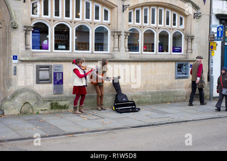 Straßenkünstler spielen Musik und Gesang auf der Hohen Straße in Wells, Somerset, Großbritannien Stockfoto