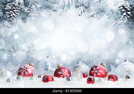 Frohe Weihnachten - Kugeln auf Schnee mit Tannenzweigen Stockfoto