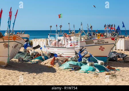 Traditionellen lokalen Stil Fischerboot mit seinen Fischen Fahnen und schwimmt auf der Strand von Monte Gordo, Algarve, Portugal Stockfoto