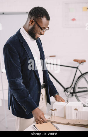 Professionelle heiter afrikanischen amerikanischen Architekten arbeiten mit Business Gebäude Modell im Büro Stockfoto