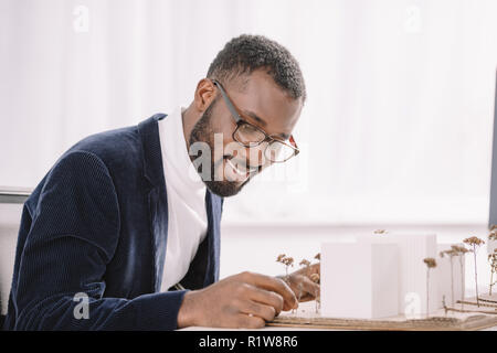 Lächelnd bärtigen african american Engineer arbeiten mit Business Gebäude Modell Stockfoto