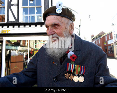 Weltkrieg zwei Veteran George Evans im Alter von 95 das Tragen roter Mohn und weißer Frieden Mohn mit seinem quäker Abzeichen am Barett an der Trauerfeier eine Parade in Stockfoto