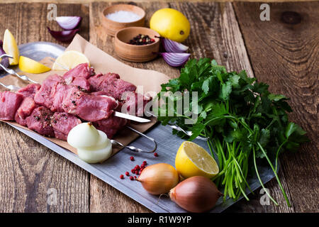 Rohe frische Rindfleisch Spieße, Metzgerei ungekocht gehacktes Fleisch und Zutaten zum Kochen auf hölzernen Tisch Stockfoto