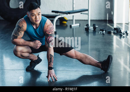 Junge Sportler tun Hocke Übung im Fitnessstudio Stockfoto