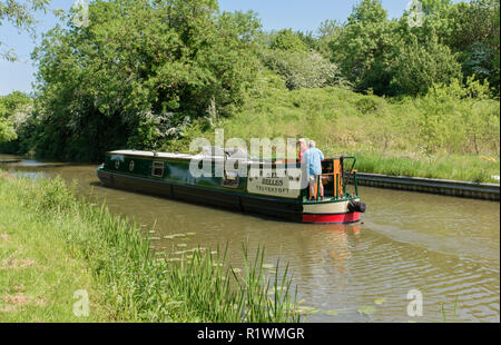 15-04 unterwegs mit zwei Menschen, die am Heck des Bootes reisen entlang der Market Harborough Kanal Arm, Foxton Locks, Leicestershire. Stockfoto