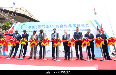 Chinesische und kenianischen Delegation und Investoren geführt von Kenyas Kabinettsminister für Ministerium für Handel, Industrie und Genossenschaften Peter Munya (Mitte) und der Chinesischen Leiter der Ausstellung Delegation Wang Xiaoguang (3. rechts) gesehen schneiden Bänder während der Veranstaltung. China und Kenia statt eine industrielle Kapazität Zusammenarbeit Ausstellung in Nairobi, Kenia. Es ging um die Unterzeichnung von bilateralen Kooperationen in den Bereichen der Infrastruktur, in der Produktion und bei Unternehmen haben im afrikanischen Kontinent einschließlich Kenia. Stockfoto