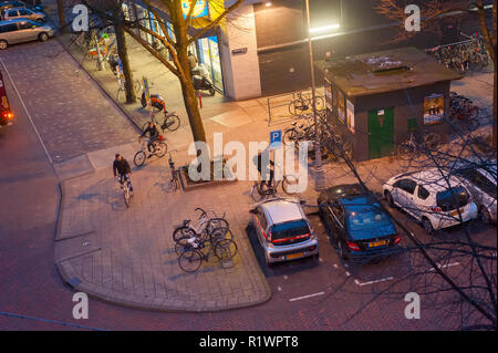 Blick über Amsterdam Straße mit Fahrrad und Pkw Parkplatz am Abend beleuchtet, Niederlande Stockfoto