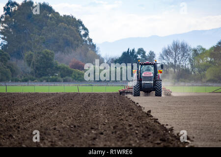 Temuka, Canterbury, Neuseeland - 14. September 2018: Bauer für das Seeding mit Case Traktor pflügen ein Feld bereit und und ein Pflug Stockfoto