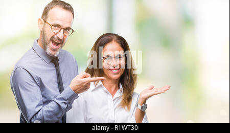 Mittleres Alter spanischer verliebtes Paar Brillen über isolierte Hintergrund erstaunt und lächelt in die Kamera während der Präsentation und mit der Hand nach w Stockfoto