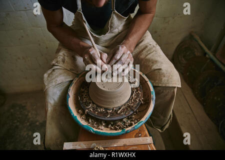 Zugeschnittenes Bild von professionellen Potter dekorieren Tontopf in Werkstatt Stockfoto