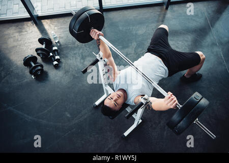 Blick von oben auf die konzentrierten Sportler Training mit Langhantel im Fitnessstudio Stockfoto