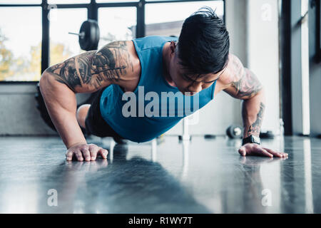 Junge Sportler tun plank Übung im Fitnessstudio konzentriert Stockfoto