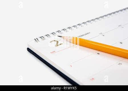 Februar Kalender und Bleistift auf weißem Hintergrund. Stockfoto
