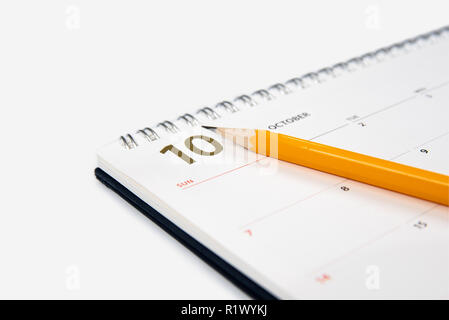 Oktober Kalender und Bleistift auf weißem Hintergrund. Stockfoto