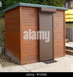 Kreative Holz- Strand Wc mit gepanzerten Jalousien an der Tür. Outdoor Herbst Landschaft Stockfoto