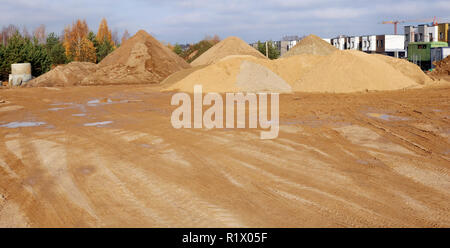 Ein großer Haufen von Bau Sand mit Spuren von Räder des Schleppers auf Stadt Baustelle. Panoramablick auf die Collage aus mehreren outdooe Schüsse Stockfoto