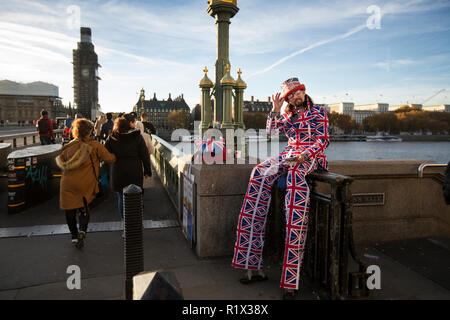 Mann mit Union Jack gedruckt Klage auf Stelzen am südlichen Ende der Westminster Bridge, London, England, UK stand Stockfoto