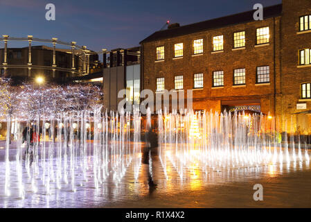 Weihnachtsschmuck zu den Fontänen im Kornhaus Platz in der Dämmerung, am Kings Cross, London, Großbritannien 2018 Stockfoto