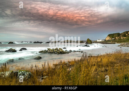 Diese photographe war bei Sonnenuntergang am Strand in der Nähe von ballintoy Hafen genommen Stockfoto