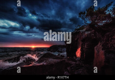 Stürmische Sunset Küste. Bunte imposante Himmel an einem windigen Abend am Lake Superior. Lebendige seascape Hintergrund mit kopieren. Stockfoto