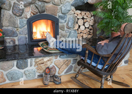 Mann mit seinen Füßen bis entspannend Vor seinem Haus Kamin, MT, USA Stockfoto